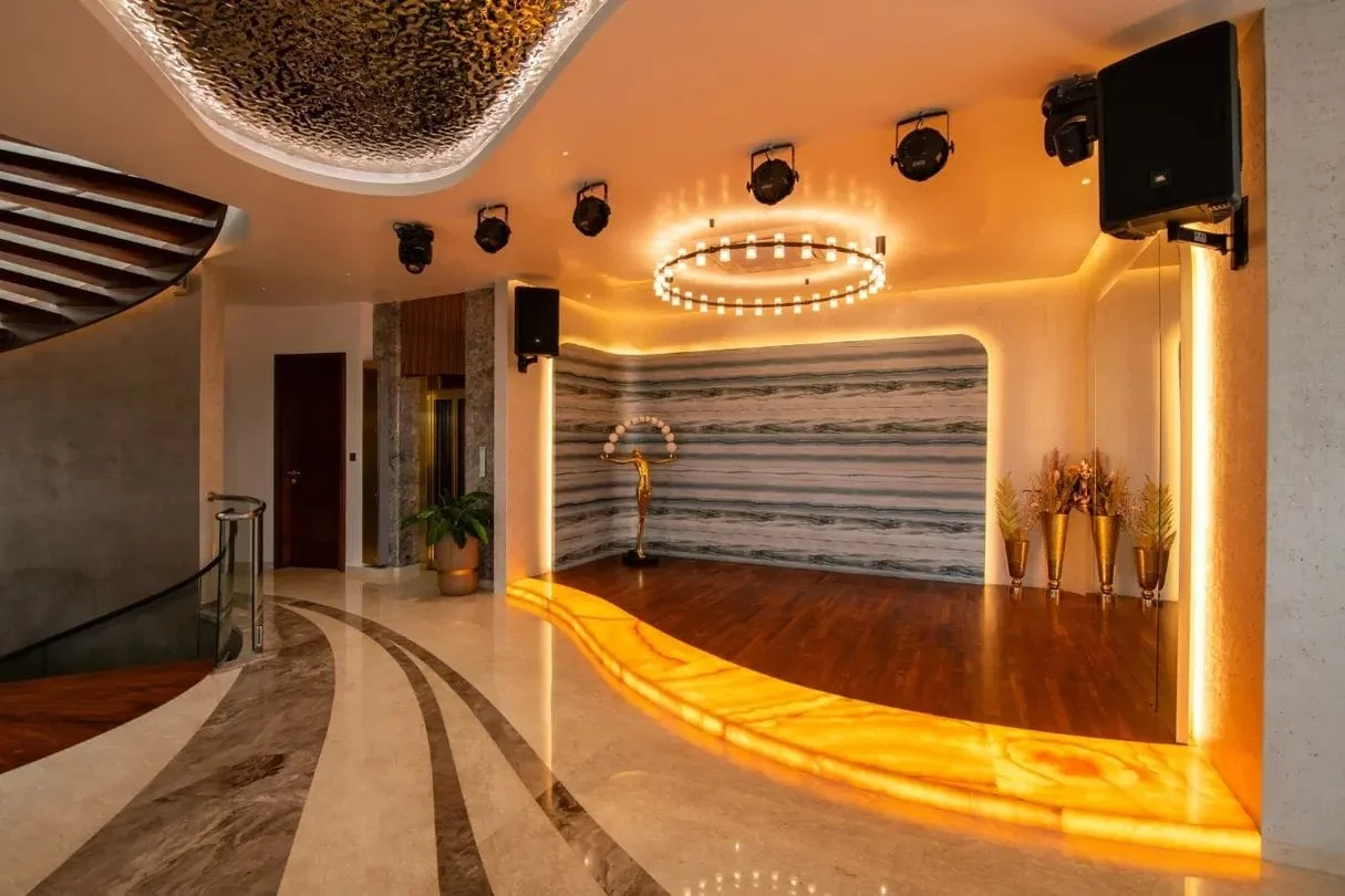 Elevated performance lounge stage with curved illuminated translucent onyx riser and perimeter cove lighting