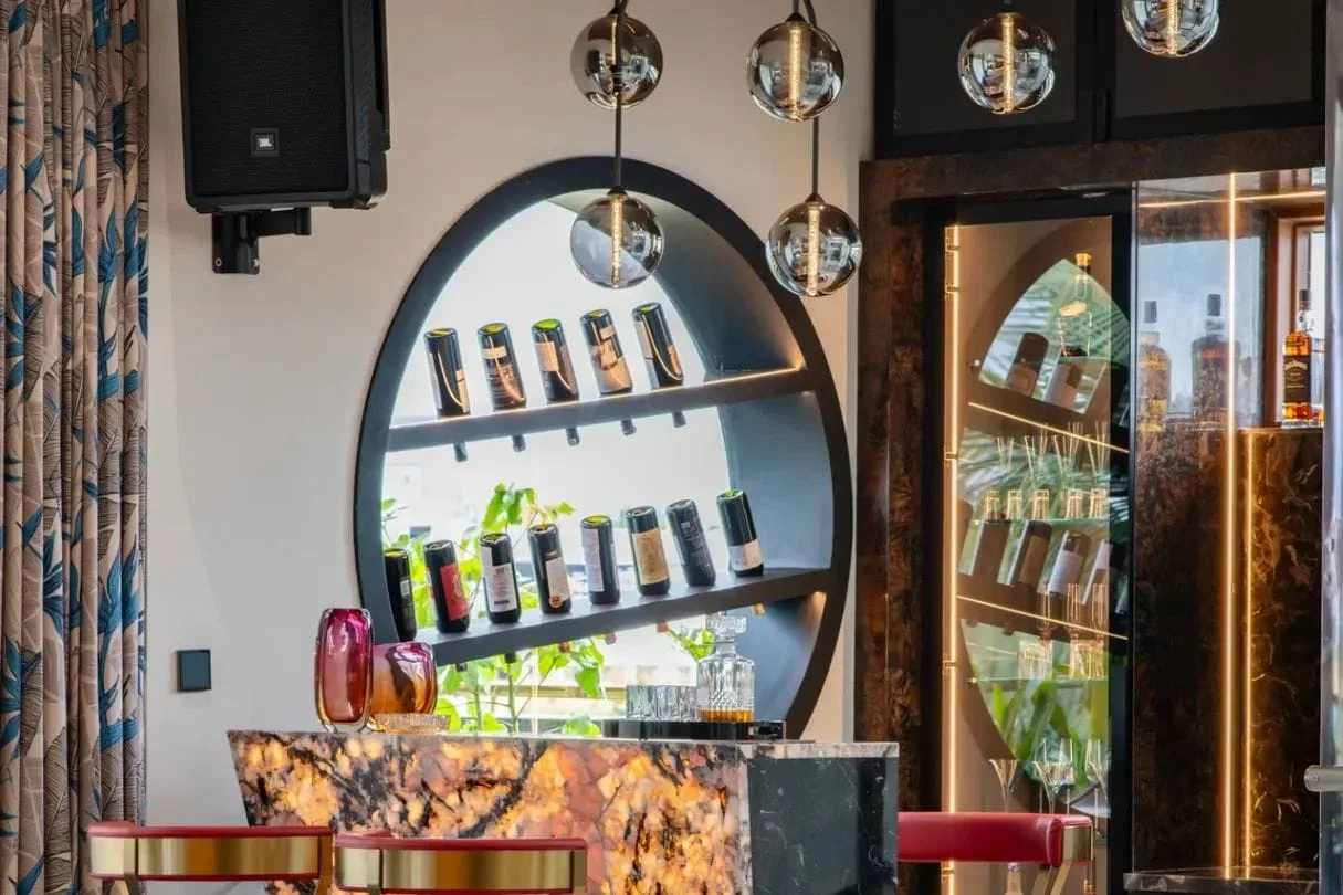 Custom bar counter crafted with backlit translucent onyx stone and circular wine display